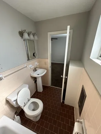 a bathroom with a sink mirror and toilet