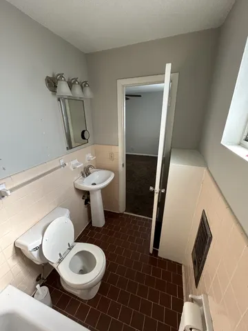 a bathroom with a sink mirror and toilet