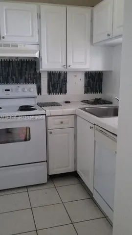 a kitchen with cabinets appliances and a sink