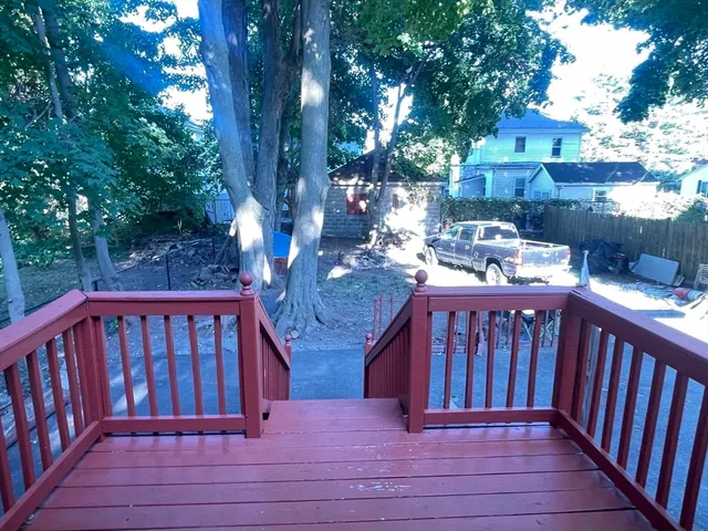 a view of deck with furniture and trees