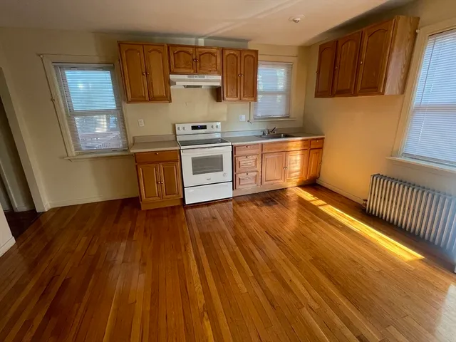 a kitchen with wooden floors and white appliances
