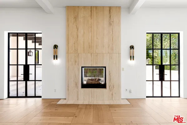 a view of a hallway with wooden floor and windows