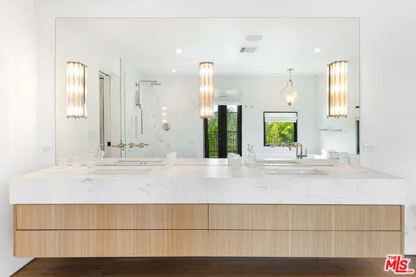 a bathroom with a sink a mirror and a shower
