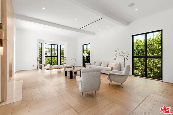 a living room with furniture and large windows