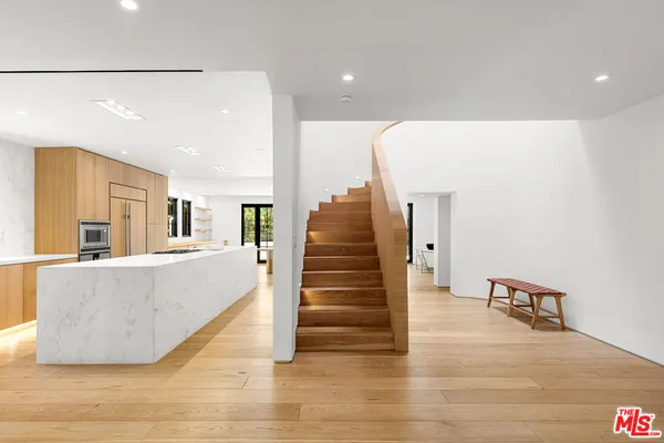 a view of entryway and hall with wooden floor