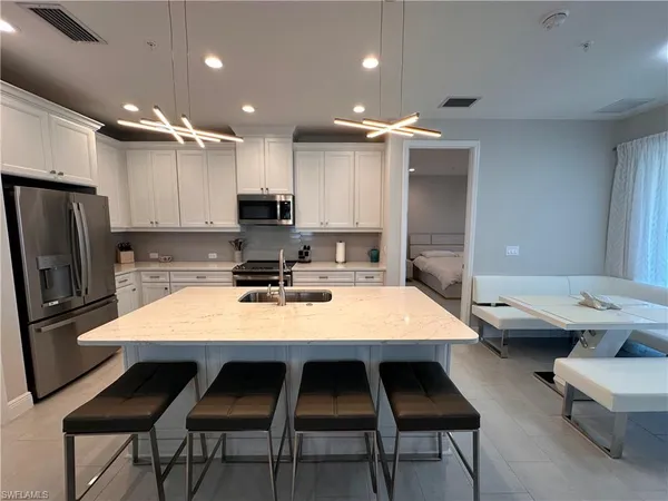 a kitchen with a table chairs sink and refrigerator