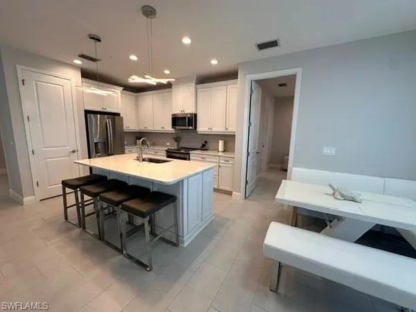 a kitchen with a table chairs refrigerator and microwave