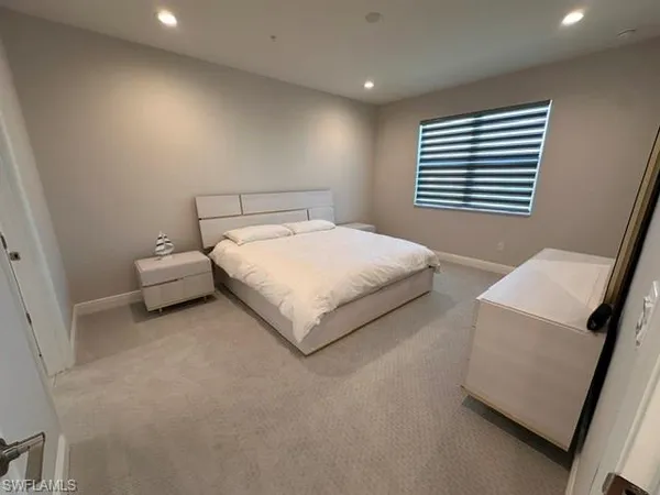 a bedroom with a bed and a large window