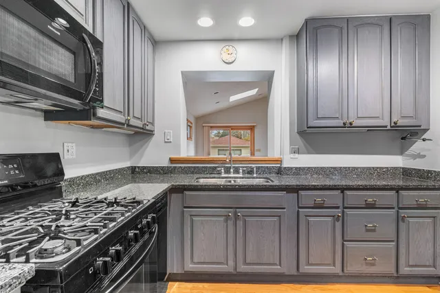 a kitchen with granite countertop a stove and a sink