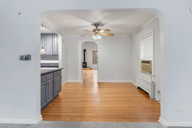 a view of an empty room with a kitchen and a window