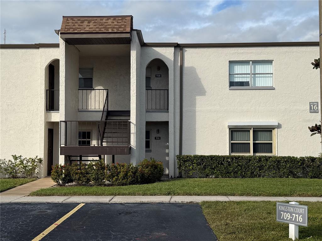 a view of a house with brick walls and a yard with plants
