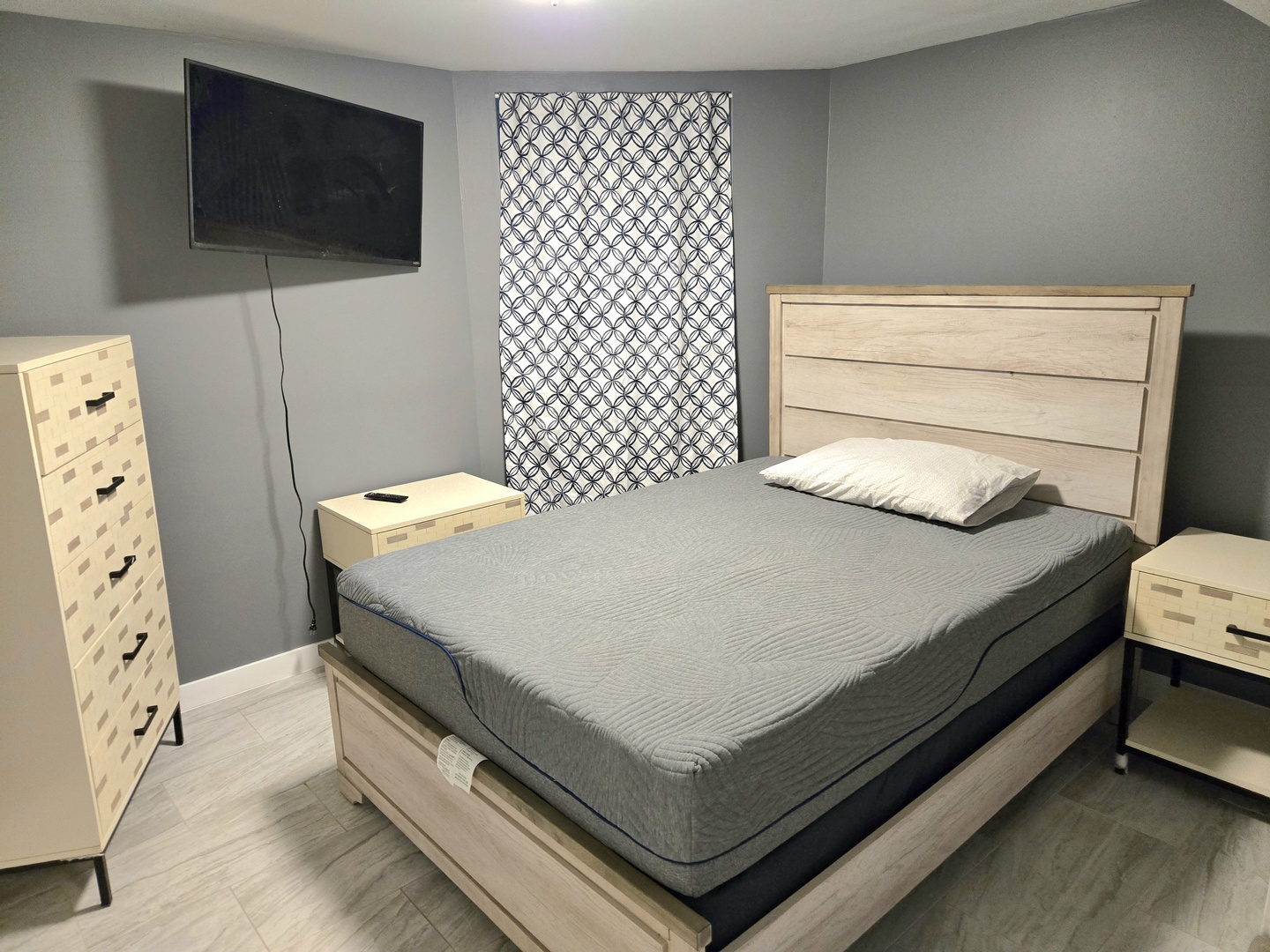 6137 South Kimbark Avenue, Unit B Chicago, IL 60637 - Photo 13 of 20 a bed sitting in a bedroom next to a flat screen tv on dresser and a wooden floor