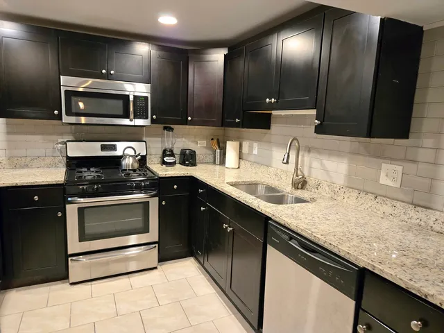 a kitchen with stainless steel appliances granite countertop a sink and stove top oven