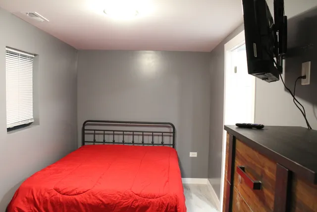 a bedroom with a bed and flat screen tv