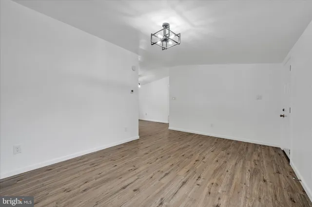 a view of a room with wooden floor and a ceiling fan