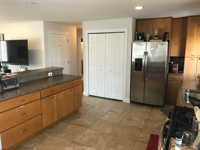 a kitchen with stainless steel appliances granite countertop a refrigerator and a sink