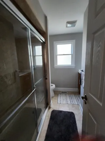 a bathroom with a toilet and a shower
