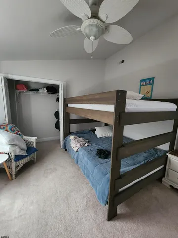 a bedroom with a bed and a ceiling fan