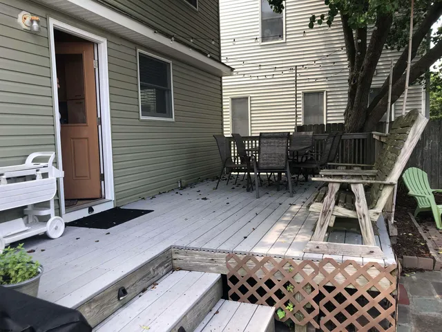 a terrace with wooden floor table and chairs