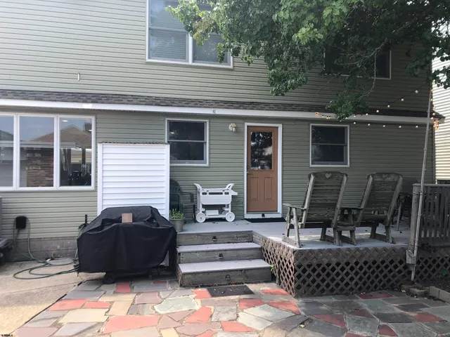a view of a patio with two chairs and a potted plant