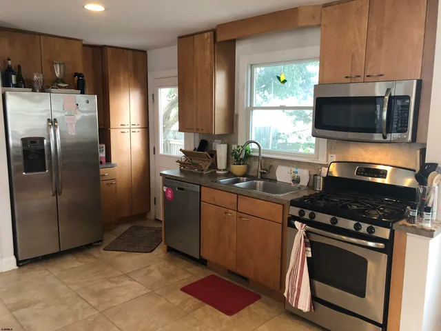 a kitchen with stainless steel appliances granite countertop a stove a refrigerator and a microwave