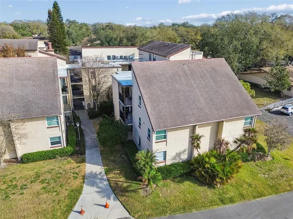 an aerial view of a house with a garden and lake view