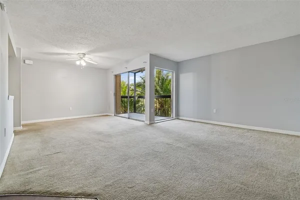 an empty room with closet and a ceiling fan