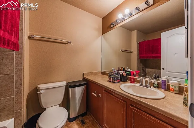 a bathroom with a granite countertop sink toilet mirror and a shower