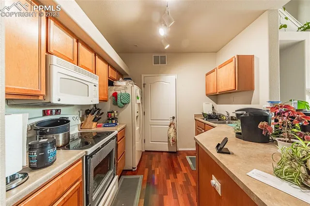 a kitchen that has a lot of cabinets a sink and appliances in it