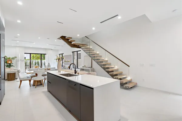 a room with lots of white furniture and wooden floor