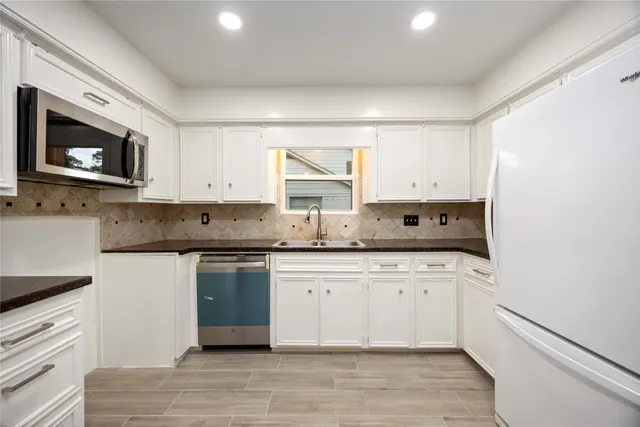 a kitchen with stainless steel appliances granite countertop a stove a sink and a microwave