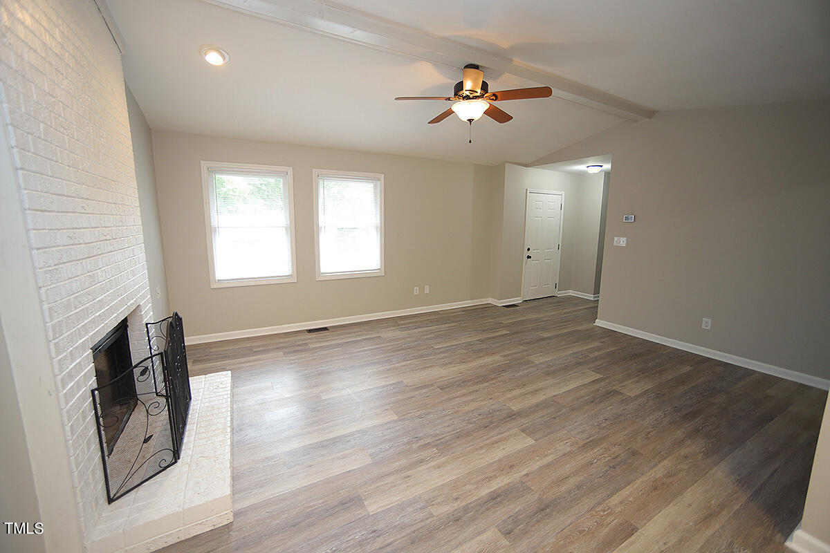 8009 Boxer Place Wake Forest, NC 27587 - Photo 3 of 11 an empty room with wooden floor and chandelier fan