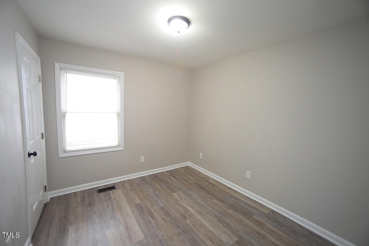 8009 Boxer Place Wake Forest, NC 27587 - Photo 9 of 11 an empty room with wooden floor and windows