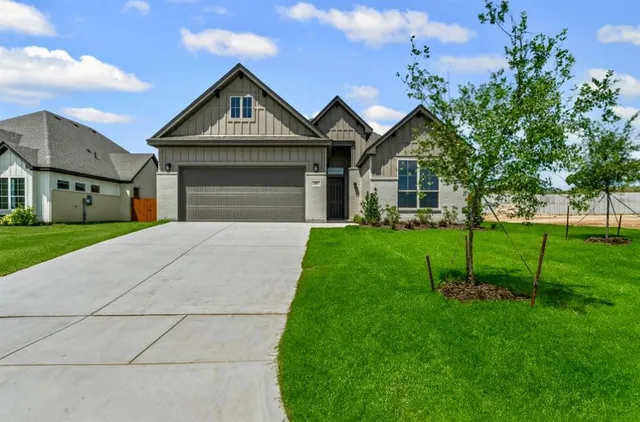 a front view of a house with a yard and trees