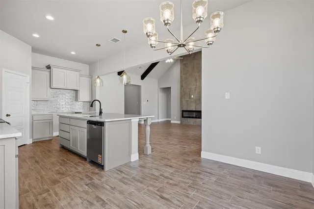 a kitchen with a sink cabinets and wooden floor