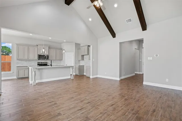 a view of kitchen with refrigerator and white cabinets