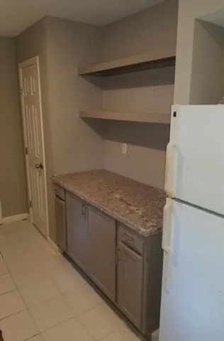 a kitchen with granite countertop cabinets and refrigerator