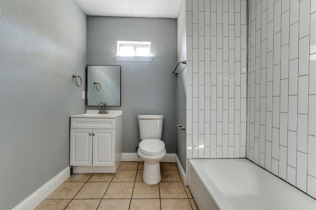 2238 Macon Street Dallas, TX 75215 - Photo 11 of 12 a bathroom with a toilet a sink and mirror