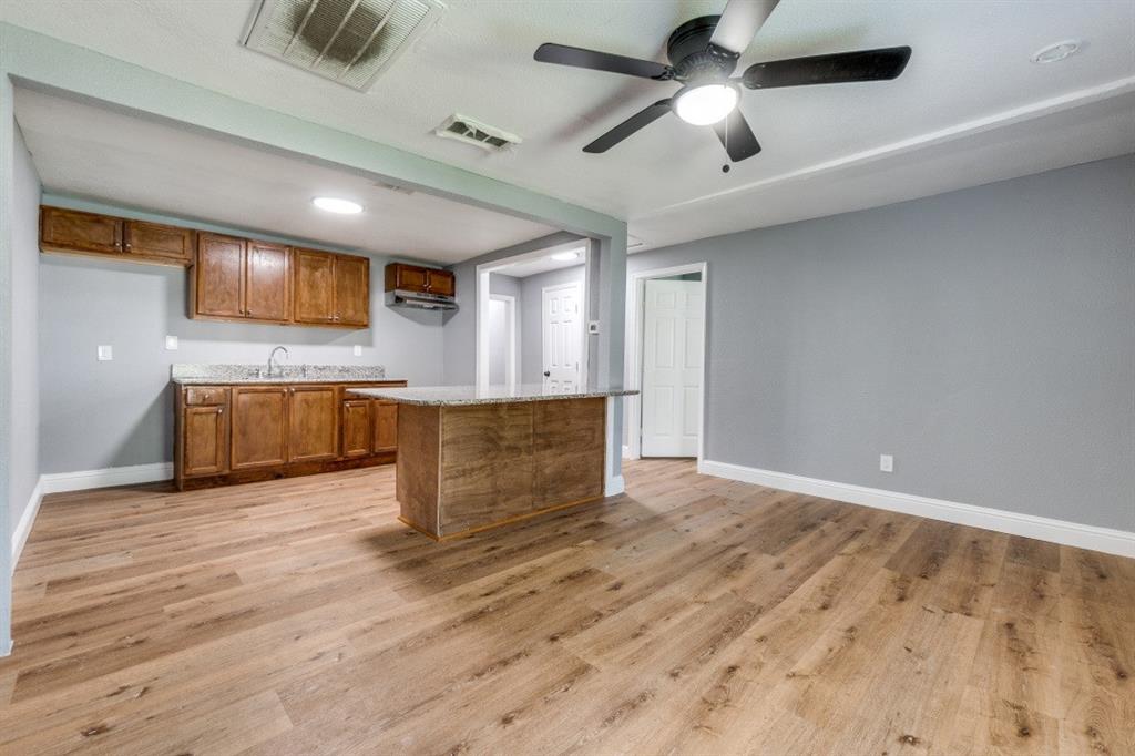 2238 Macon Street Dallas, TX 75215 - Photo 3 of 12 a kitchen with kitchen island a sink stainless steel appliances and a chandelier