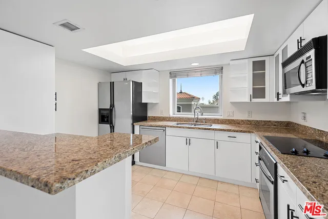 a kitchen with granite countertop sink and cabinets
