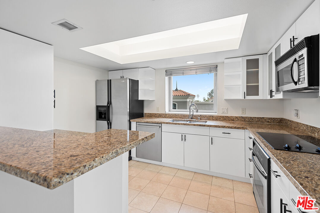 13700 Marina Pointe Drive, Unit 517 Marina del Rey, CA 90292 - Photo 3 of 54 a kitchen with granite countertop sink and cabinets