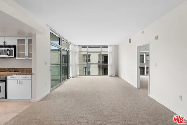 a view of an empty room with a kitchen