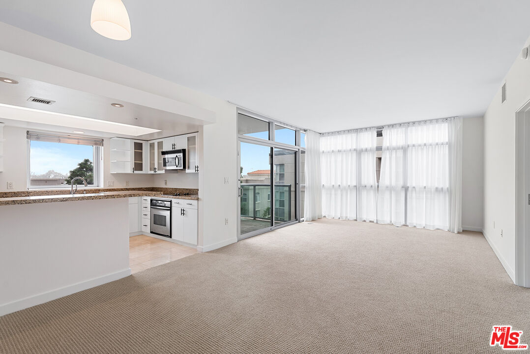 13700 Marina Pointe Drive, Unit 517 Marina del Rey, CA 90292 - Photo 8 of 54 a big room with windows and view of kitchen