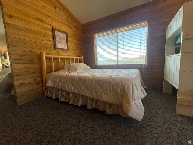 4648 West Taylor Flt Road Salina, UT 84654 - Photo 9 of 20 Wood-paneled room featuring a window with horizontal blinds, a wood-frame bed, and patterned carpet