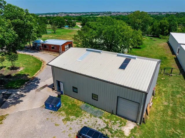 an aerial view of a house with swimming pool and a yard
