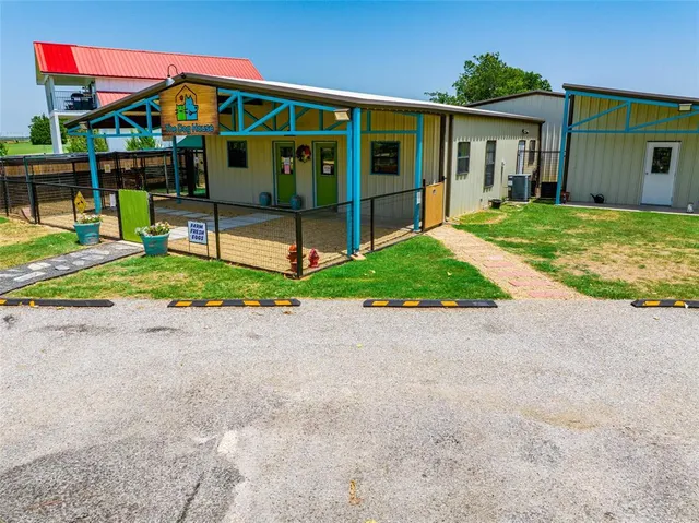a view of a white house with large trees and outdoor space