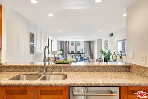 a kitchen with kitchen island granite countertop a sink and a counter top space