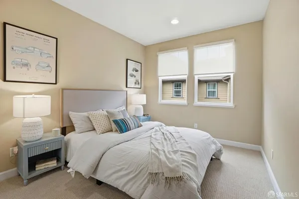 a bedroom with bed and a lamp on dresser