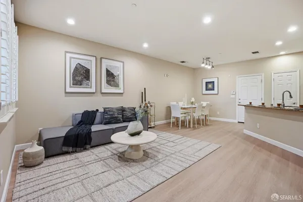 a room with stainless steel appliances kitchen island granite countertop a couch and a coffee table