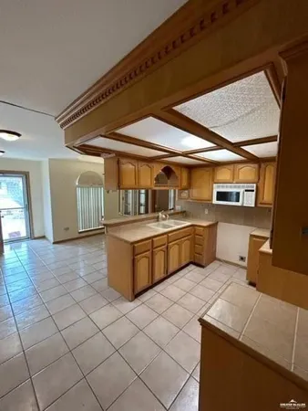 a kitchen with a sink a stove top oven and cabinets